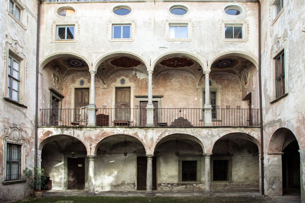 Cortile interno di palazzo Merizzi con porticato su due piani e cornici alle finestre