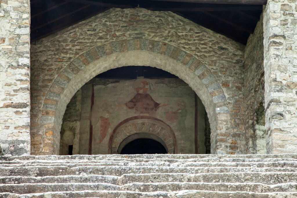 Porta della basilica con affresco di Cristo nel mezzo del pronao semicircolare