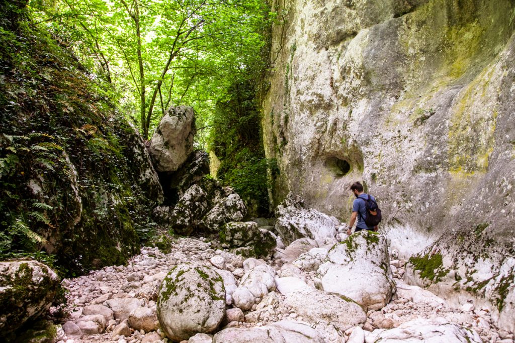 Discesa tra le grandi rocce nel trekking delle gole di Celano