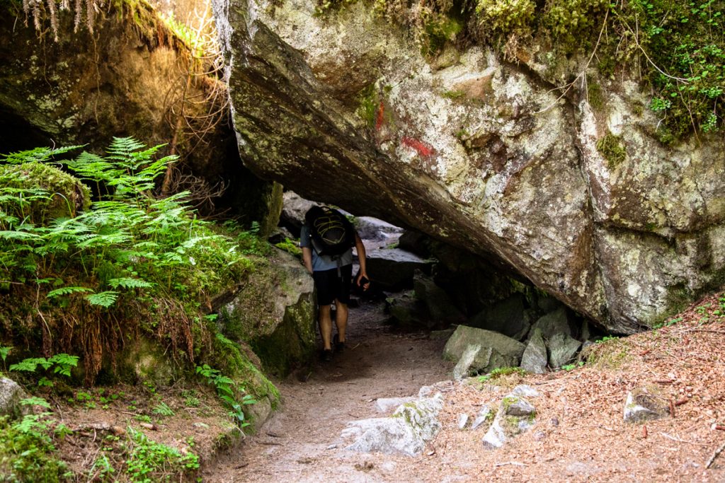 Chinarsi sotto alla roccia lungo il sentiero delle Cascate