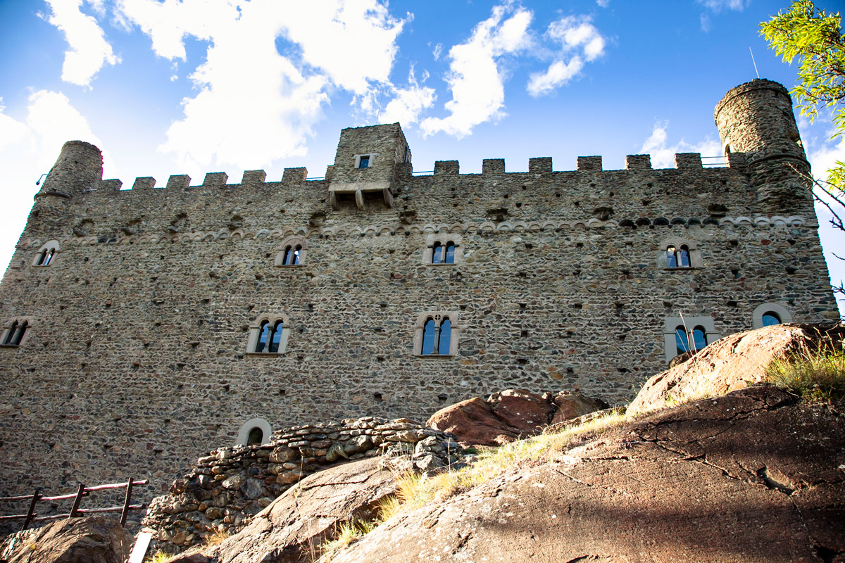 Facciata meridionale del castello di Ussel con torrette circolari angolari e caditoia sopra ingresso e merlature