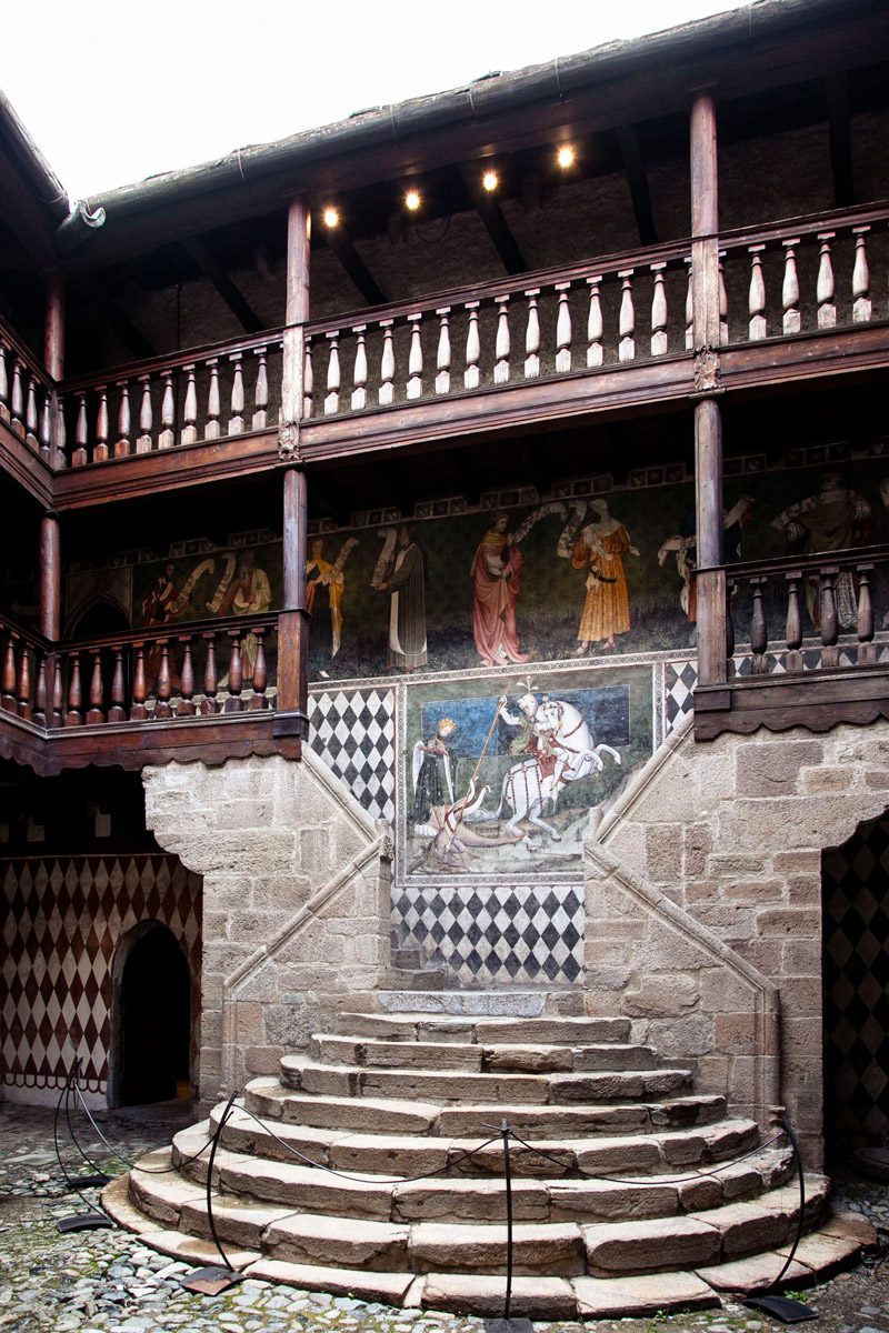 Gli affreschi e la scala semicircolare nel cortile del castello