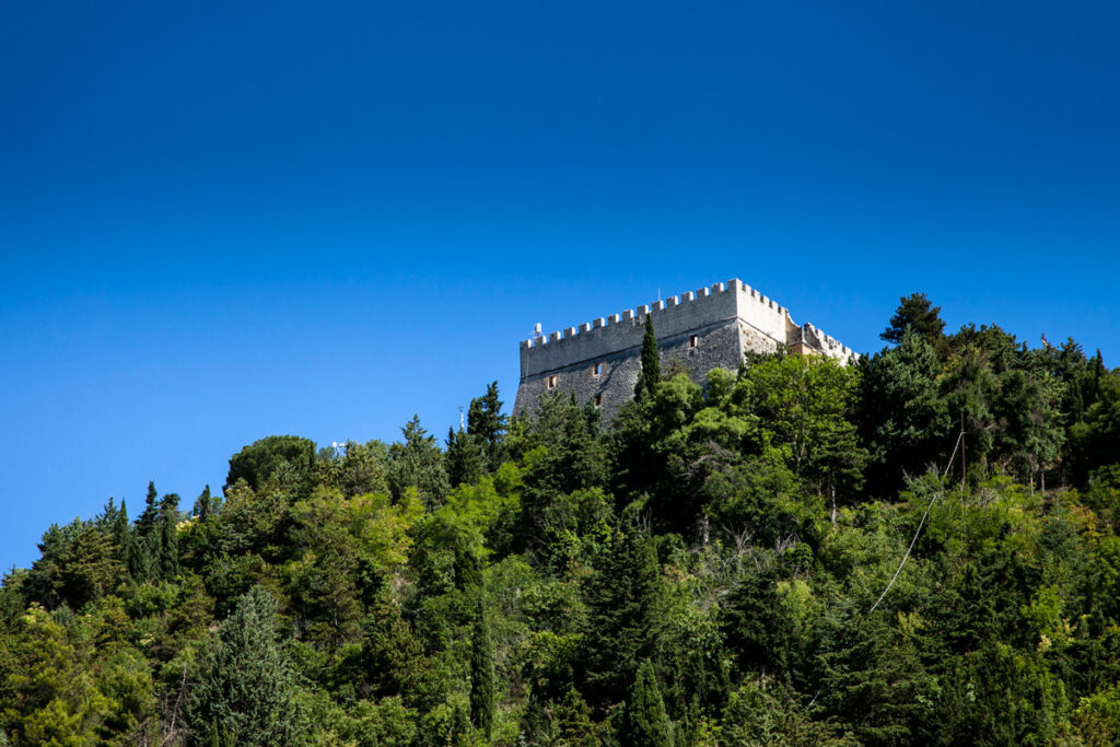Castello Monforte visto sulla collina tra la vegetazione