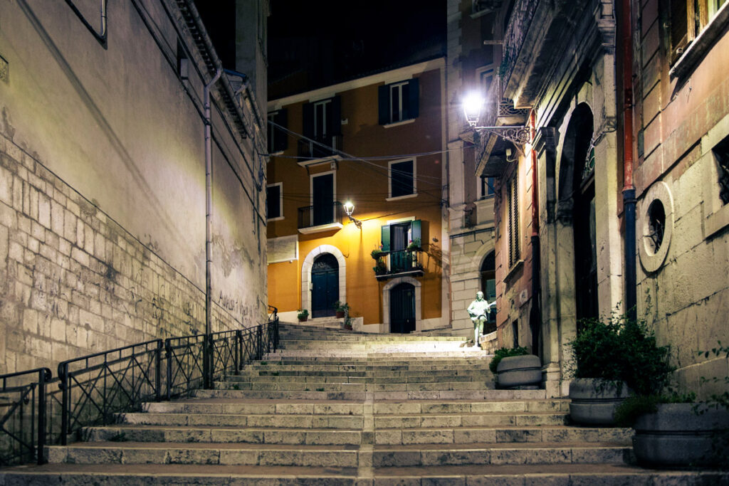 La scalinata di via Chiarizia di sera con la statua di Fred Bongusto
