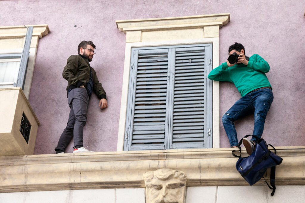Ragazzi in bilico sul cornicione di un palazzo - Oltre la Soglia - Leandro Erlich
