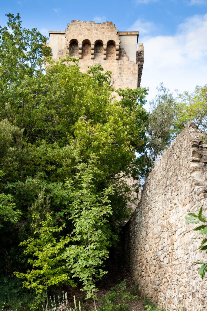 Torre del Cassero Senese tra la vegetazione del giardino del Cassero